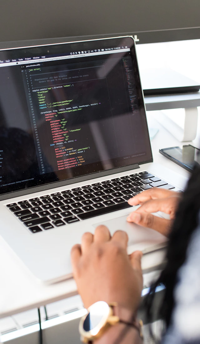 Hands typing code on a laptop, shown inside a phone frame